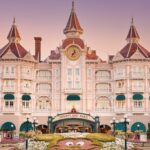 Disneyland Hotel bij de ingang van Disneyland Paris met roze gevel en torentjes in de avondzon