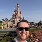 Selfie van een bezoeker bij het Kasteel van Doornroosje in Disneyland Paris met zonnige blauwe lucht