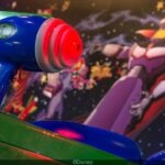 Close-up van laserblaster in Buzz Lightyear Laser Blast met keizer Zurg op de achtergrond