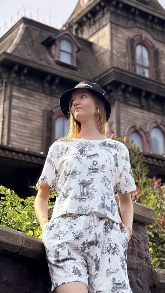 Model in witte tweedelige set met spookhuisprint voor Phantom Manor in Disneyland Paris