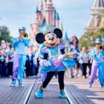 Minnie Mouse leidt een marching band op Main Street, U.S.A. met het kasteel op de achtergrond in Disneyland Paris