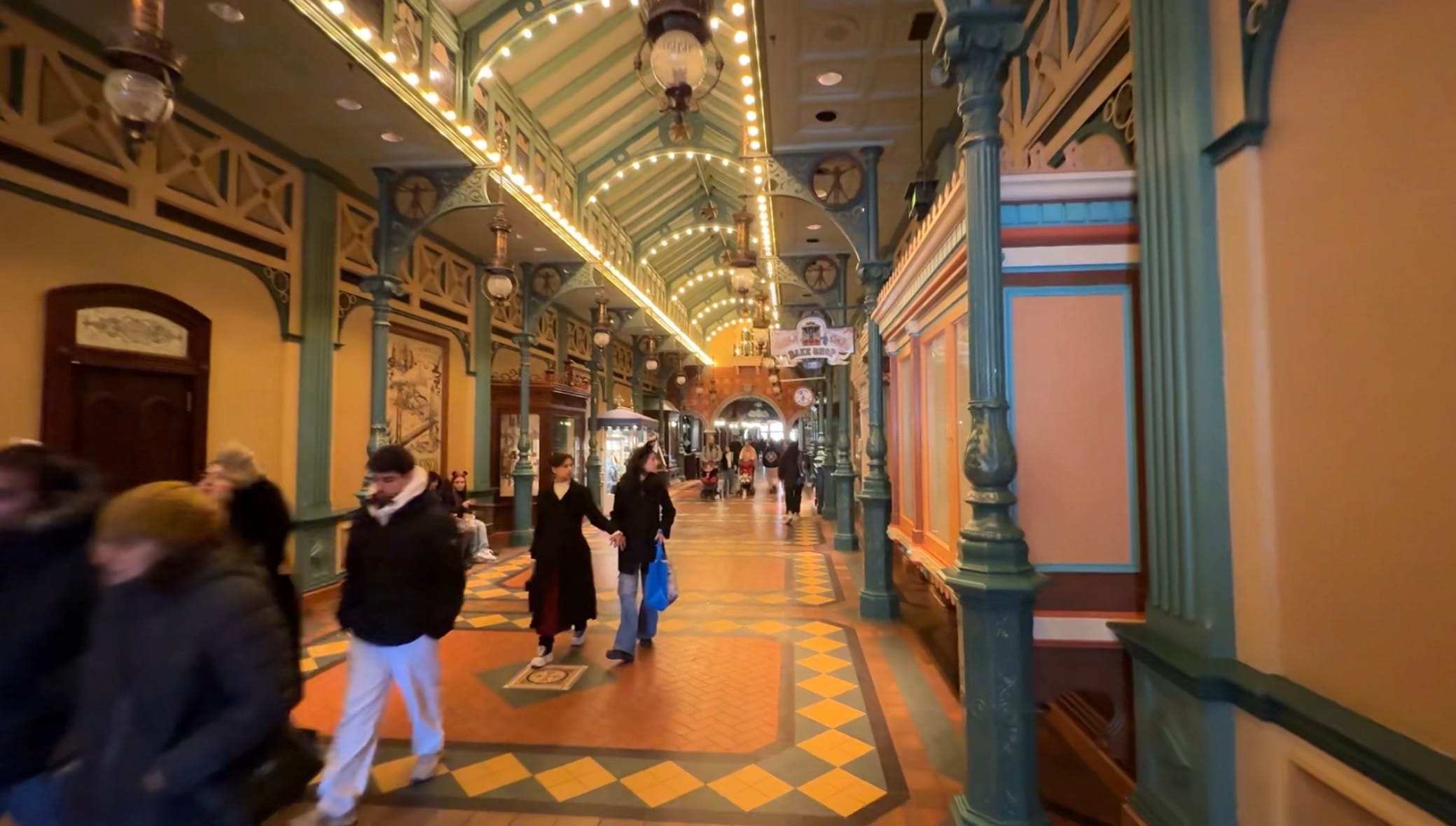Guests walking through the covered Liberty Arcade passage on Main Street, U.S.A. at Disneyland Paris