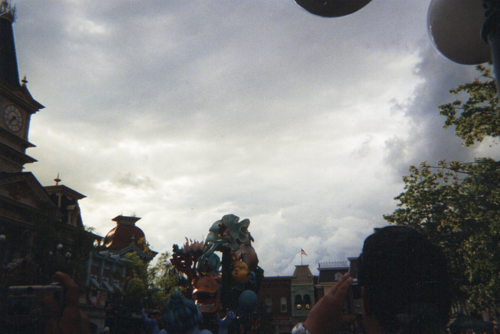A colorful parade float passing beneath a cloudy sky on Main Street, U.S.A., Disneyland Paris
