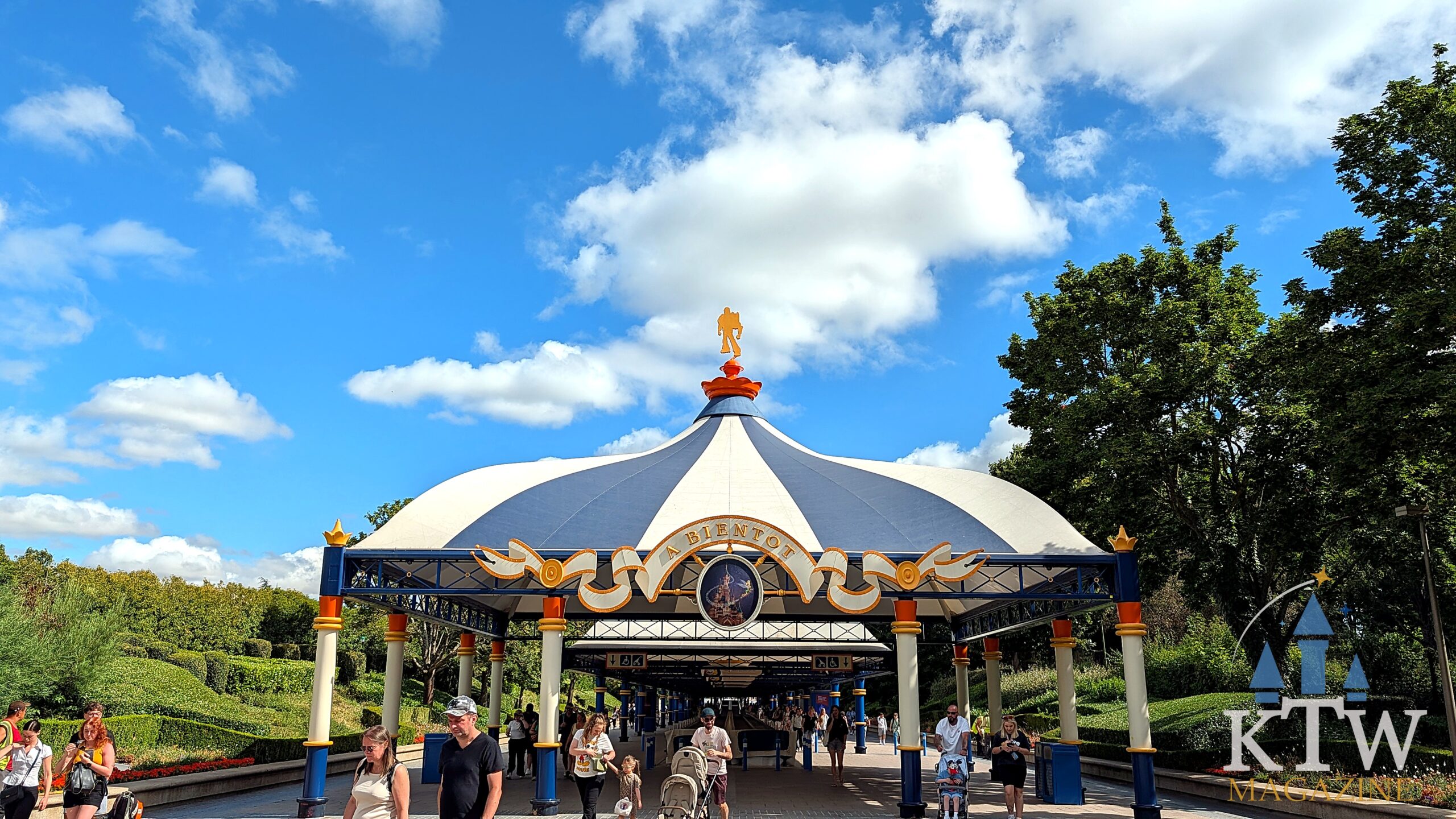 Bezoekers lopen onder het blauw-witte koepelpaviljoen van Discoveryland, waar Hyperspace Mountain in Disneyland Parijs ligt