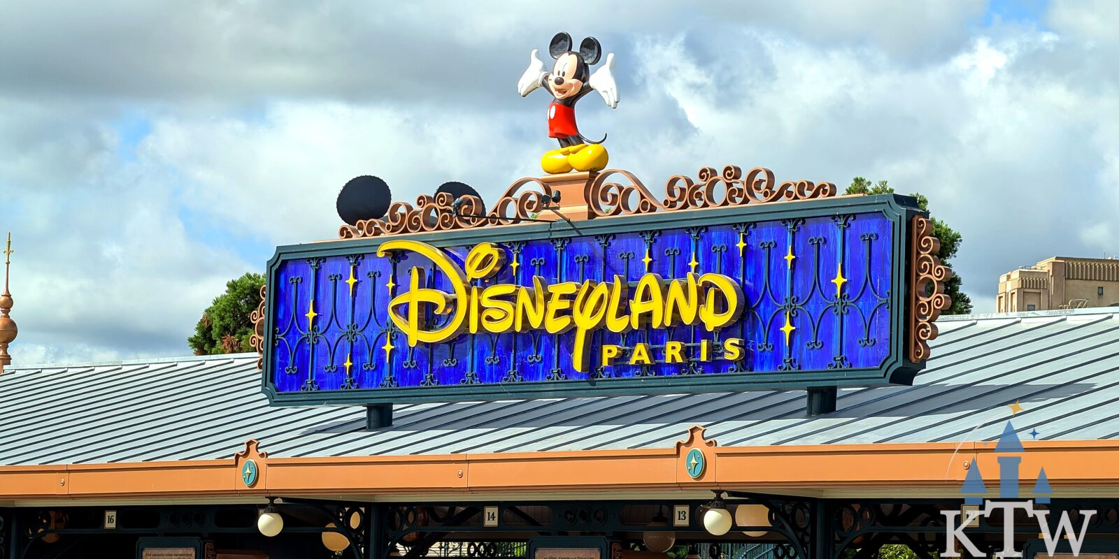 Close-up van het verlichte Disneyland Paris-entreebord met Mickey Mouse boven de ingang