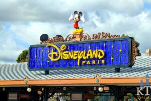 Close-up van het verlichte Disneyland Paris-entreebord met Mickey Mouse boven de ingang