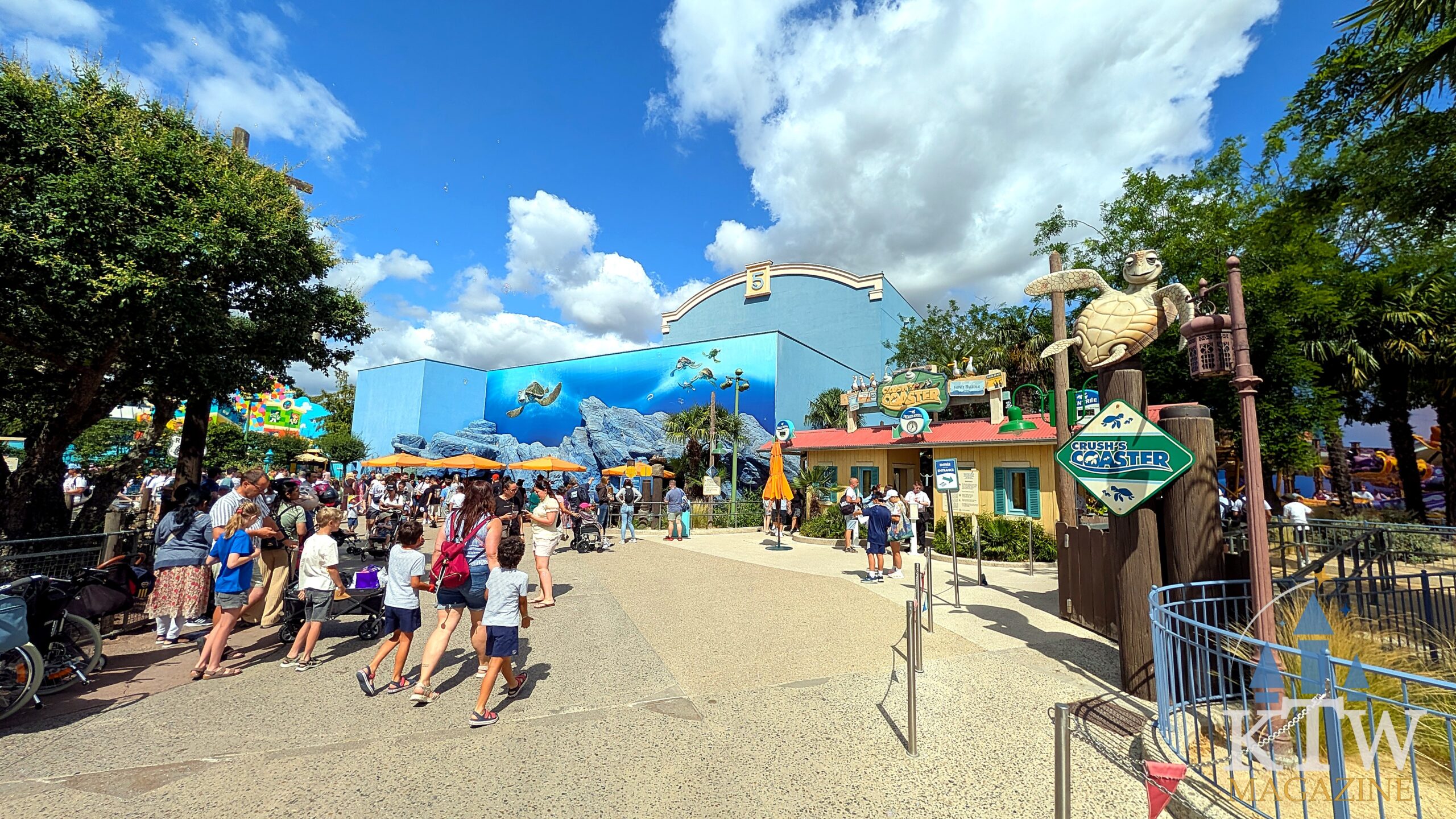 A large group of visitors walking towards the entrance of Crush's Coaster