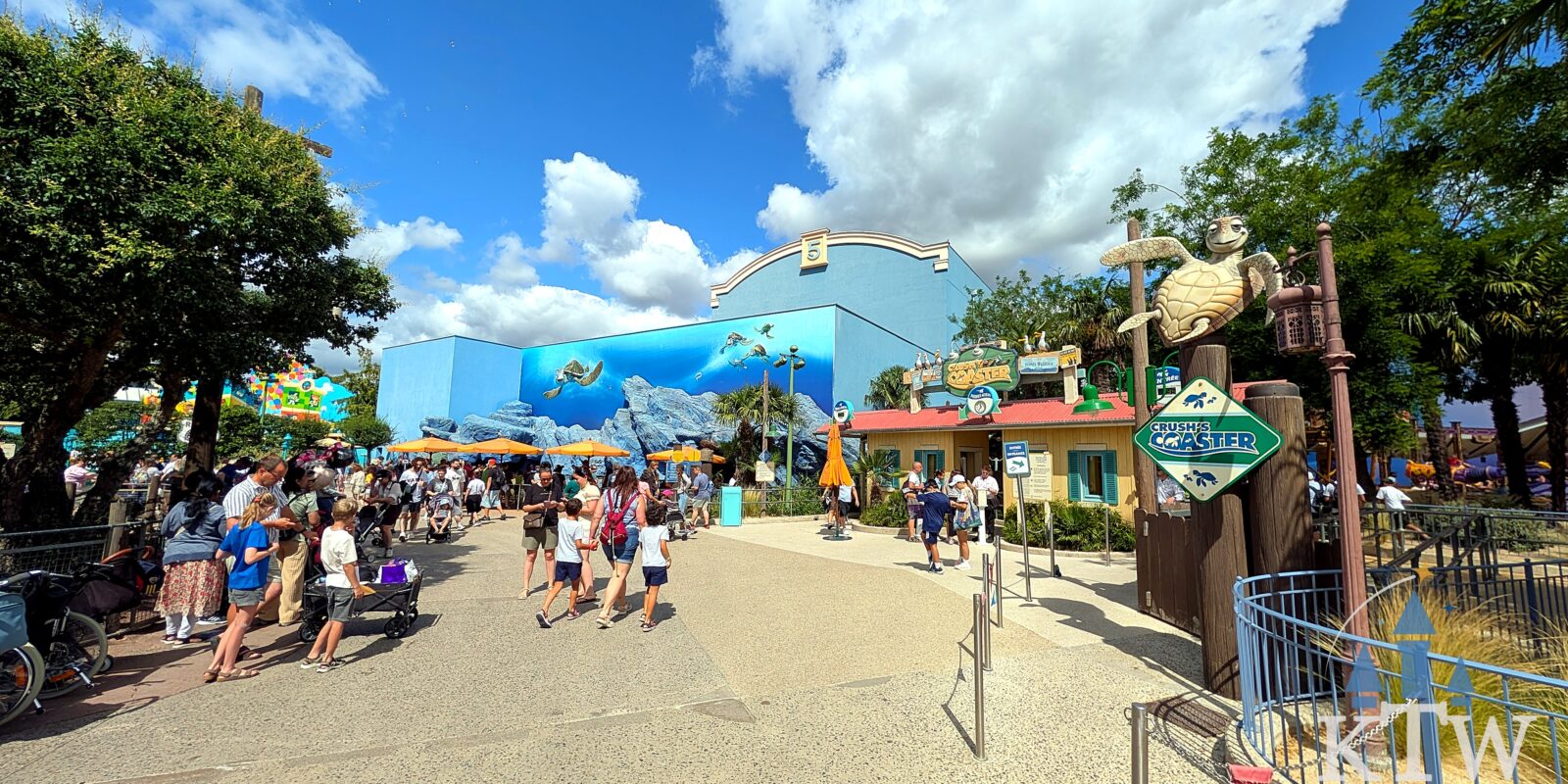 Bezoekers lopen over het pad richting Crush's Coaster langs het Finding Nemo-gebouw