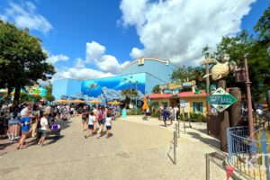 Bezoekers lopen over het pad richting Crush's Coaster langs het Finding Nemo-gebouw