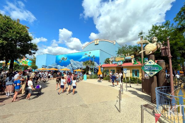 Bezoekers lopen over het pad richting Crush's Coaster langs het Finding Nemo-gebouw