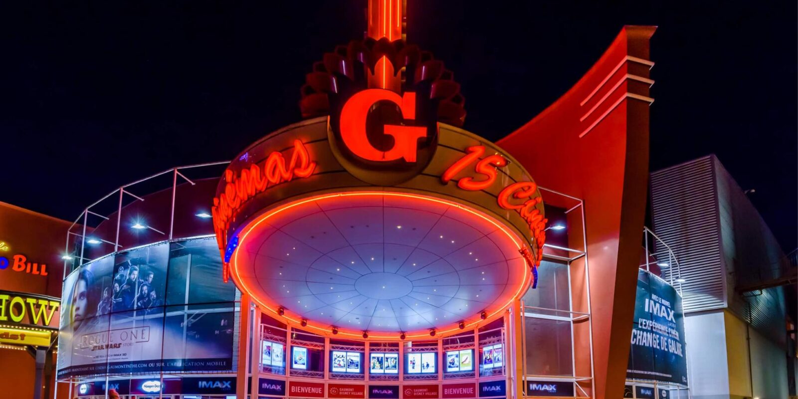 De bioscoop in Disney Village bij nacht, met het kenmerkende gevelontwerp vóór de renovatie